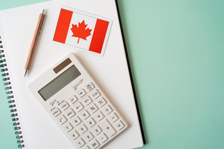 Flag of Canada, calculator, and pen on a notebook