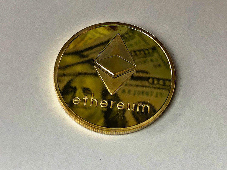 Image of large gold Ethereum coin on gray background
