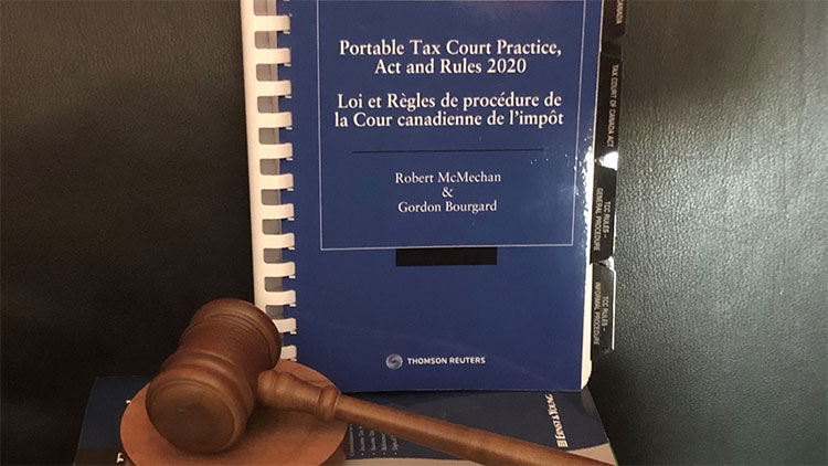 Image of blue book that reads “portable tax court practice, act and rules 2020” beside a wooden gavel