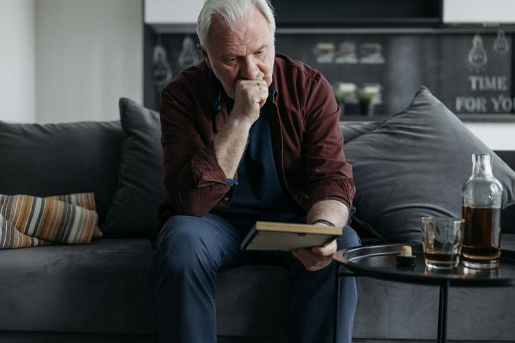 An Elderly Man Looking at a Picture Frame