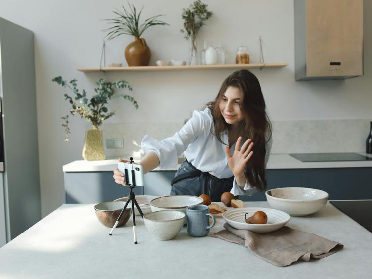 A Woman Waving her Hand at her Smartphone while Recording a Video