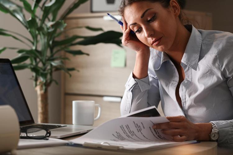 Businesswoman contemplating while working on paperwork