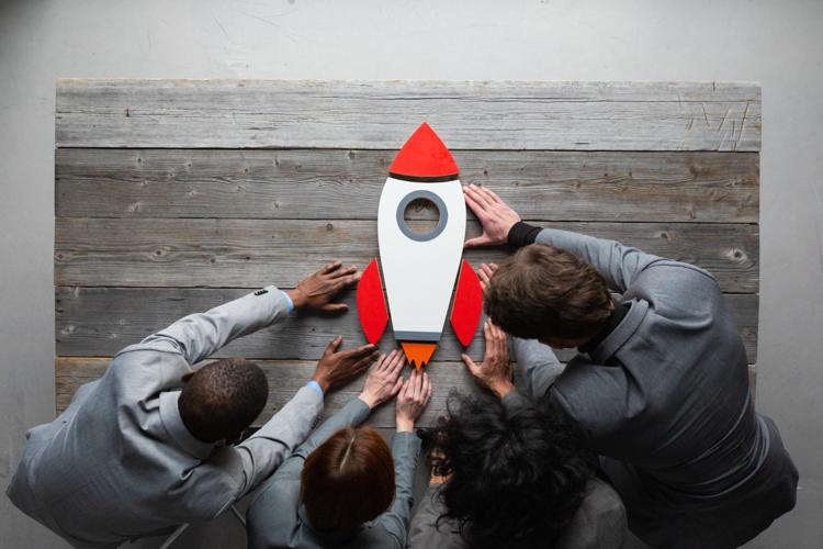 Creative team with startup rocket