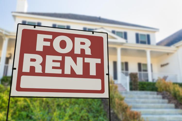 A "For Rent" sign in front of a house