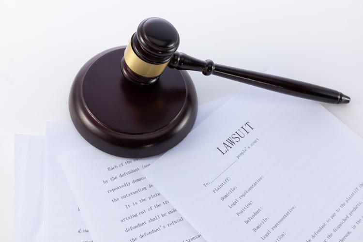 Close-up shot of the judge's gavel on a document of a lawsuit.